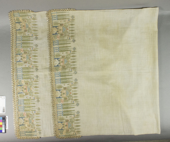 Hearst Museum object titled Towel, accession number 9-14999, described as Mortuary towel. Cotton, silk, metal wrapped yarns. Plain weave, embroidered, some drawn work, lace edging. White ground, varicolored designs. 46 x 23 in. Variation of "mosque and cyprus" designs. Published: "At the Edge of Asia: Five Centuries of Turkish Textiles" #12 in catalogue