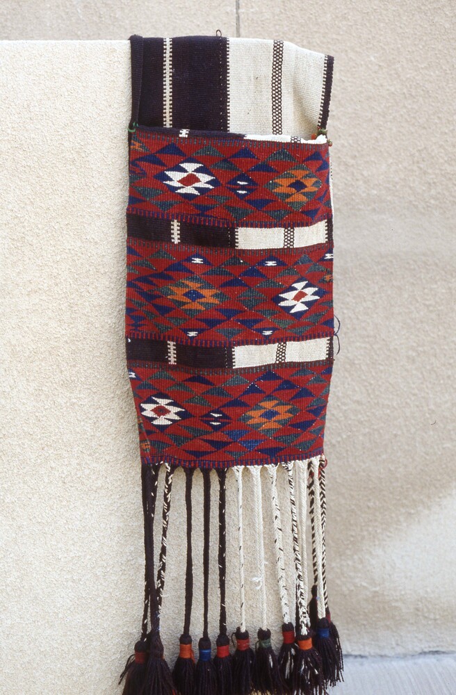 Hearst Museum object titled Color slide, accession number 25-98507, described as 35mm color slide transparency. Textile with striped and triangle patterns; featuring tassel detailing; colored red, orange, green, blue, black, and white.