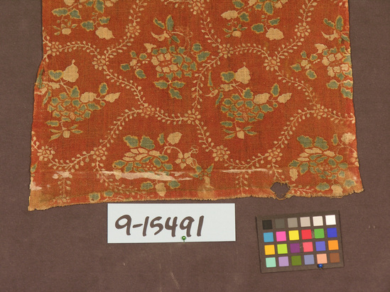 Hearst Museum object titled Textile fragment, accession number 9-15491, described as Strip, two selvedges; cotton; plain weave, resist dyed, possibly stenciled; red ground of "Akuma," rose madder, blue, green, yellow, white designs; 13 by 18 inches; floral motives, Tokugama period, "Akuma women," Japanese characters on back in ink.