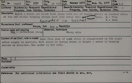 Documentation associated with Hearst Museum object titled Apron, accession number 5-13407, described as Oko- ceremonial strap., Kenya, Gob Ore, Rendille. Summer, 1977. 5-13407, acc no. 3332. Orig. No. 137. File code: 5.3 Collector: Jean Colvin. Donor: Jean Colvin. Materials, techniques: Sheep skin Context of use: Made from skin of goat which is slaughtered on 5th night after a couple is married. Wife wears it during Soreo or Almado- wears it hanging across on shoulder. Man makes it for wife. Description: Apron- brown and black hide piece with row of cowrie shells on leather strap at top and double hanging straps each with metal bell and keys. Located in barrel. L=71 cm. W=34 cm. References: for additional information see field sheets in acc. env.