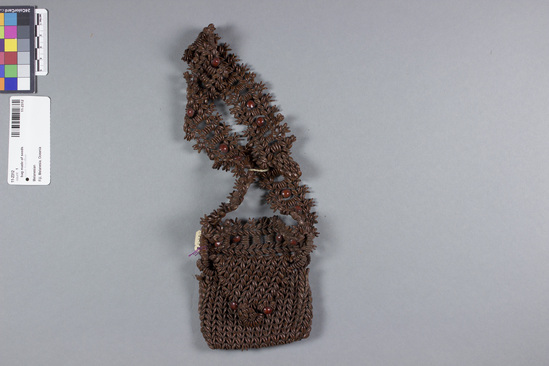 Hearst Museum object titled Bag, accession number 11-2312, described as Bag made by sewing together flat, brown seeds similar to flax seeds; elaborate handle and button for closing; few red seeds