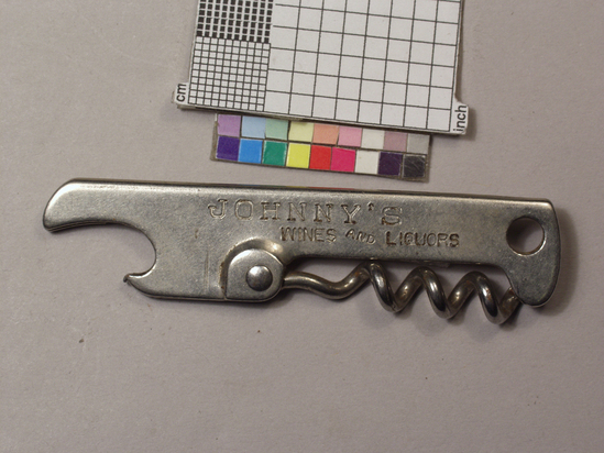 Hearst Museum object titled Bottle opener, accession number 2-68947, described as Key ring advertising giveaway, 20th Century. Corkscrew/caplifter combination; nickel plated steel sheet stock folded in half into handle; crown caplifter at one end, hole at opposite end; folding wire helical worm pivoting on rivet at center; handles die stamped: 2-68947) "Johnny's Wines & Liquors" 2-68948) "Nifty" 2-68949) "P. Welty & Co. Pittsburgh, Pa. " 2-68950) "Newton Liquor"; ea 7.3 cm long