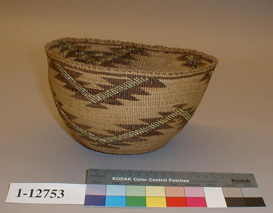 Hearst Museum object titled Cooking basket, accession number 1-12753, described as Cooking basket; twined. Warp is Tule (Schoenoplectus acutus), weft is split Tule. White pattern is Reed (Phragmites vulgaris). Brown dye is split Tule. Yellow dye is Porcupine quills (Erethizon dorsatum) in Wolf lichen (Letharia vulpina). Small, with double horizontal zigzag pattern.  Indigenous name: maksa. Bright pink quill on side, possibly a property mark.