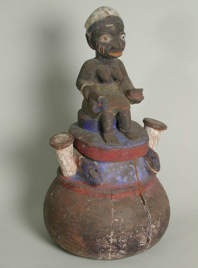 Hearst Museum object titled Bowl and lid, accession number 5-15513a,b, described as bowl.  wood, carved, polychrome, figures of snakes around upper edge, on top of lid, a seated female figure, bowl and lid cracked, paint worn away.  A) bowl - h. 12 cm., diam. 13.6 cm. approx., B) lid h. 16.2 cm.