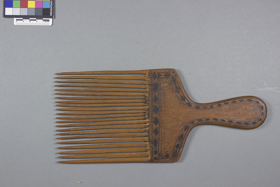 Hearst Museum object titled Comb, accession number 11-42708, described as comb, wood, pyroengraved diamond design along perimeter of handle; 22 teeth; 31.4 cm long, 13.9 cm wide; hair ornament