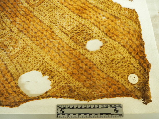 Hearst Museum object titled Cloth fragment, accession number 16-2019, described as Large fragmentary fabric similar to number 16-2018, design chiefly in yellow and brown in diagonal bands.