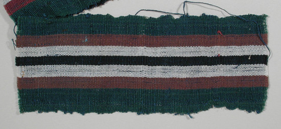 Hearst Museum object titled Textile fragment, accession number 5-11222, described as textile sample (section of narrow band weaving): green side panels; central stripe of black flanked by white and  maroon.