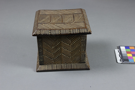 Hearst Museum object 4 of 8 titled Carved wooden box, accession number 11-42799a,b, described as Box and lid, wood, carved in relief, geometric pattern on lid and two sides of box, facial image carved on other two sides of box; tan and brown.