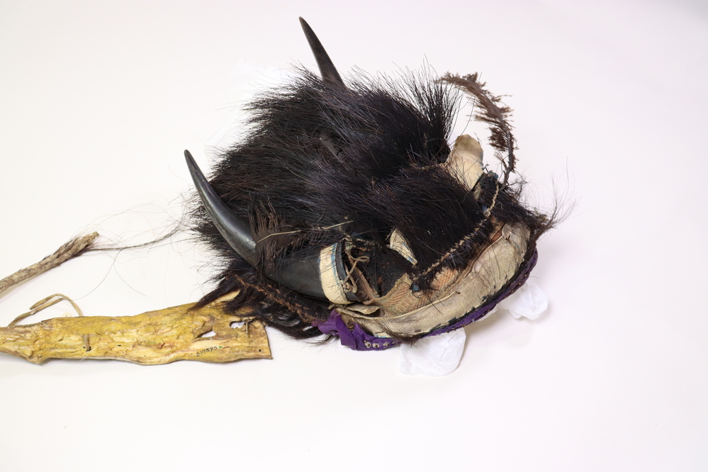 Hearst Museum object titled Headdress, accession number 2-19595, described as Buffalo. Foundation is European felt hat; decorated with rawhide strips; horsehair tufts; woven European band; purple sequined ribbon; 2 buffalo horns; rawhide trailer.