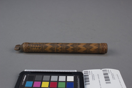 Hearst Museum object 2 of 2 titled Lime container and stopper, accession number 10-2220a,b, described as A) Bamboo lime container; incised geometric designs, band of plaited rattan around each end; 7¾ inches long B) Wood stopper, Bontre headdress shape.