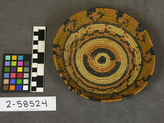 Hearst Museum object titled Basket, accession number 2-58524, described as Hobby basket; black and orange designs; coiled raffia; flat bottom, slightly flaring sides.