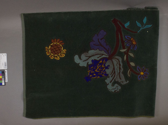 Hearst Museum object titled Textile, accession number 2-62855, described as Irregular cotton and wool strip. Cut pile, embroidered. Pounce bag markings. Green ground with varicolored designs. Floral motifs.