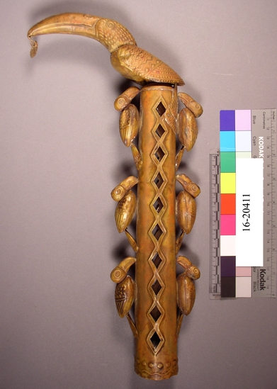 Hearst Museum object titled Staff top, accession number 16-20411, described as Chimu style staff top. Toucan atop hollow cylinder with cut diamond-shaped holes.  six smaller toucans, 3 on each side of cylinder.