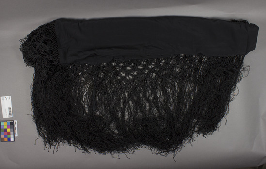 Hearst Museum object titled Shawl, accession number 7-10187, described as From Cat Card: Shawl, undecorated black silk with hand knotted fringe. all four side folded under and hemmed - knotted fringe added on all four sides. Tag label 7s attached to fringe. c1900.