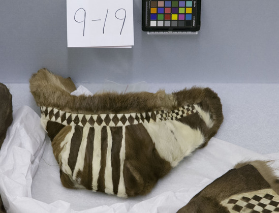 Hearst Museum object titled Cap, accession number 9-19, described as Man’s winter double cap; lining fur of very young reindeer fawn; outer cap various furs, 8 vertical stripes of alternating brown and white fur and leather in diamond and checker board patterns, fur from reindeer fawn leg.