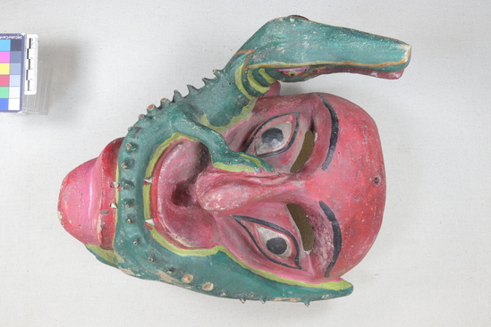 Hearst Museum object titled Anthropomorphic mask, accession number 3-28566, described as Large pink mask with crocodile in mouth