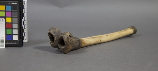 Hearst Museum object titled Thighbone trumpet, accession number 9-5272, described as Trumpet of lower 2/3 of rt.human femur (Kang-Dung);brass mouthpiece over proximal end; untanned leather sewn over distal end;l. 11.25 in.