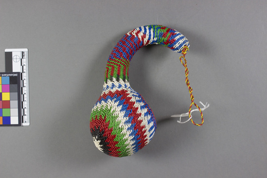 Hearst Museum object 2 of 4 titled Beer dipper, accession number 5-15352, described as Beer dipper; calabash covered with woven red, white, green, blue, and black telephone wire in a geometric design. Used to serve portions of beer. For tourist trade, domestic use-- sell or trade. Artisan: Simon Mungai.