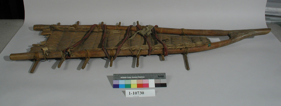 Hearst Museum object titled Cradle, accession number 1-10730, described as Cradle; twined. Warp is Tule (Schoenoplectus acutus), weft is string. On fork of wood. Made of forked stick with cross bars and covered with the tule mat on the front.