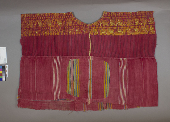 Hearst Museum object titled Huipil, child, accession number 3-155, described as Child’s garment (guipil). (Red cotton, plain weave with blue stripes. Brocaded with orange and yellow cotton. A different fabric is sewn on the bottom, red cotton with white stripes and multicolored twilled stripes. A large hole was carefully patched in back.)