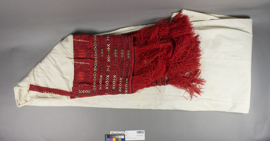 Hearst Museum object titled Gown, accession number 7-5119, described as Woman's linen chemise (kosula vodarka - "chemise of she who goes after water"); red and orange embroidered sleeves with long fringes at end.