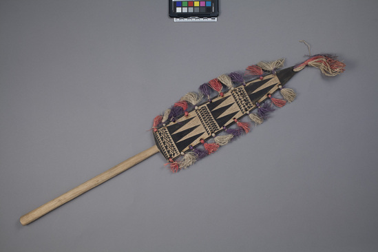 Hearst Museum object titled Paddle, accession number 11-3176, described as dance paddle, “patil”; black design, red, white and lavender fringe