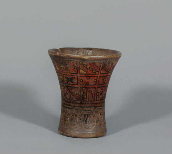 Hearst Museum object titled Beer cup, accession number 16-8465, described as Wooden corn beer goblet (Kero) with carved and painted design, flat base. Old split repaired with cord. Diameter 4.75 inches, height 5.5 inches. Probably from the 17th century. Under the colonial system these were made and used only by Indians in rites of the native religion. They were made to order for caciques who officiated at the ceremonies; they were made and used in identical pairs. Chicha, corn beer, was the liquid drunk from them and sprinkled on the ground or on the votive offerings.