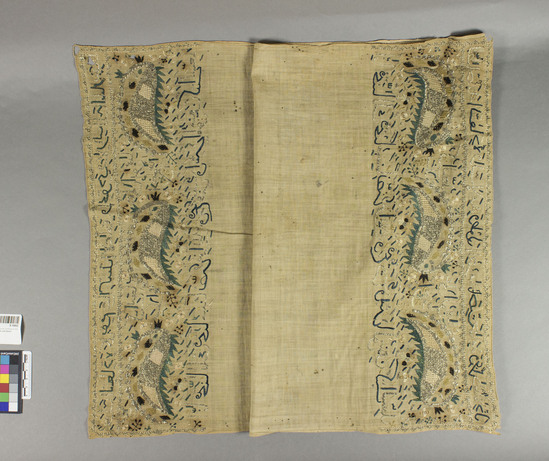 Hearst Museum object titled Koran cover, accession number 9-15002, described as Koran cover. Cotton, silk, metal-wrapped yarns. Plain weave, embroidered. Natural ground, black, green, white, and yellow designs. Leaf, flower, Arabic calligraphy motives. 43 inches by 18½ inches.