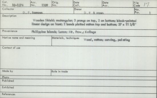 Documentation associated with Hearst Museum object titled Shield, accession number 10-1274, described as Wooden Shield; rectangular; 3 prongs on top, 2 on bottom; black-painted linear design on front; 2 bands plaited rattan top and bottom; 37 x 11 3/8”