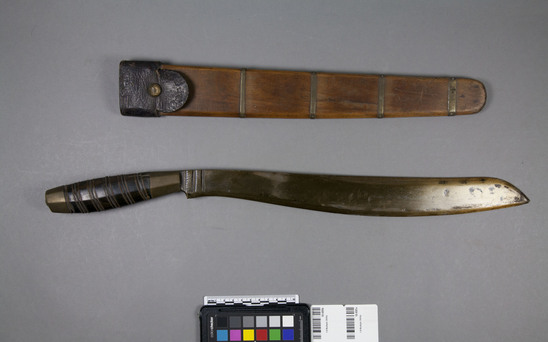 Hearst Museum object 1 of 2 titled Knife and sheath, accession number 10-695a,b, described as a) Two edged bolo, handle black horn inlaid with brass wire. b) Sheath wood, 4 strips of brass and one of leather.