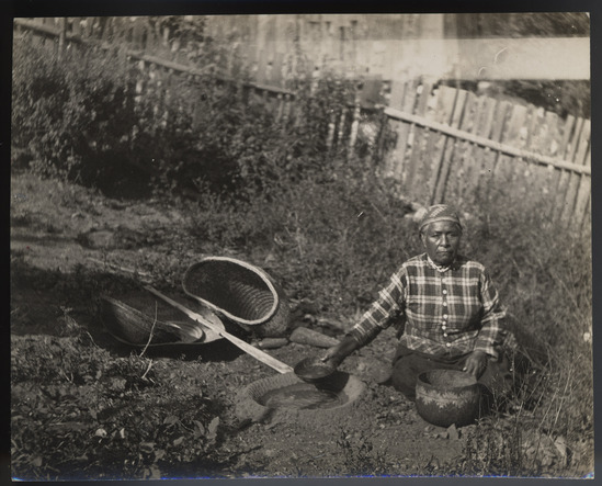 Hearst Museum object titled Photograph, accession number 13-2432, described as Mary using leaching basin. 2 prints from the collection of the Society of California Pioneers