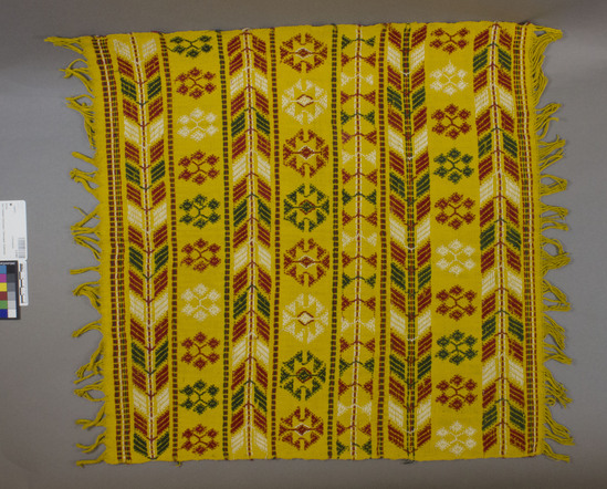 Hearst Museum object titled Napkin, accession number 3-23467, described as Servilleta (napkin): yellow cotton plain weave; covered with bands of single-face brocading; geometric designs in red, white, and green; 54.6 x 55.9 cm length. Used by "Mayordomos", possible ceremonial use for Cofradia. The Bukleb covers gourds containing coca. The designs are: a) Picaya. Chevron design, represents palm leaves b) Six-sided "X": represents "Eyes that see all" c) Diamond surrounded by triangles: represents the "Host" See also, Dieseldorf's "X Balam Q'ue, El Pajaro Sol", pg. 28