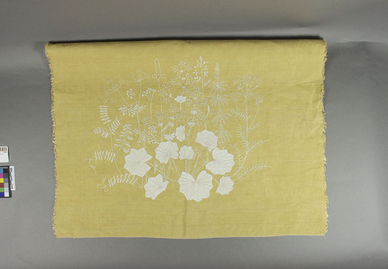 Hearst Museum object titled Textile sample, accession number 7-6888, described as Pillow Top: Gold linen embroidered and appliqued in white cotton. Design of various delicate weed-like plants grow from a large and small group of applique ivy leaves. White cotton. Embroidery. Gold and white. 24 inches square. New condition. Purchased circa 1950 in Denmark. One selvedge, three unhemmed edges. Remarks: can’t locate