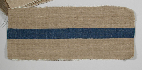 Hearst Museum object titled Textile fragment, accession number 5-11025, described as Textile sample (section of narrow band weaving). Brown-beige ground with central blue stripe (1.9 cm); white selvages.