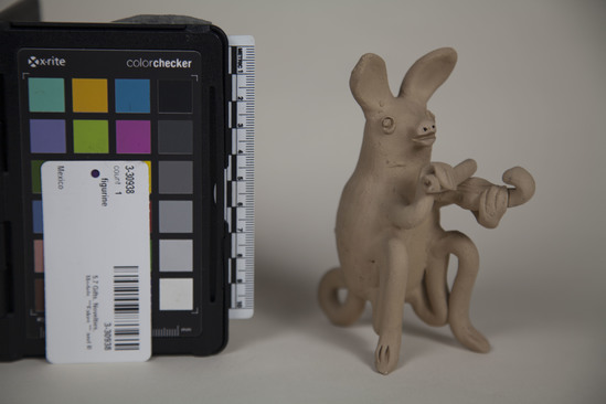 Hearst Museum object titled Figurine, accession number 3-30938, described as FIGURINE:  Ceramic figurine of a sitting animal (rabbit?) plying a violin.   Clay is natural with no slip or glaze. Oval body with applied head, legs,  tail, ears and “arms”.  A “bow” is held in the proper right hand; a small violin is held in the proper left hand.  “Mexico” is stamped in blue ink on the base of the animal’s body.  Blanco figure.