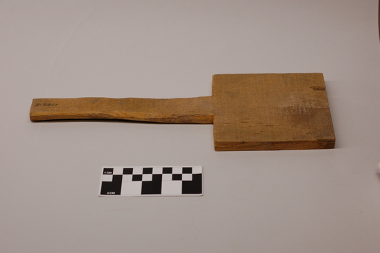 Hearst Museum object titled Paddle, accession number 3-2951, described as Wooden paddle used in pottery making, sawn from crate, with nail still present in side; hand shaped handle; L 32.2 cm x w 11.7 cm