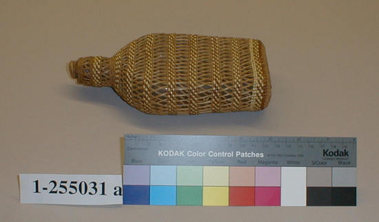 Hearst Museum object titled Bottle and lid, accession number 1-255031a,b, described as Basketry covered bottle. Flat, clear glass covered with basketry. Bands of plain twining, wheat colored and light brown, alternating with crossed stick openwork. (a) Bottle. (b) Cork stopper.  Label: "Klamath River".  Second label "Klamath R. tribes att.". Per Ralph Shanks:  Twined openwork basketry covered glass liquor bottle.  There is a cork stopper.  Crossed warp starting knot.  The warp material is probably willow or hazel.  The weft material is conifer root.  The weft overlay is red-dyed woodwardia and beargrass.  Starting at the starting knot, there is .5 inch plain twining followed by one weft row of three strand twining.  That is followed by .75 inch of plain twining, followed by alternating .5 inch crossed warp openwork and .25 inch of close twining all of the way up to the neck.  At the neck there are four weft rows of three strand twining, followed by another row of openwork, followed by .5 inch of plain twining, followed by .25 inch of openwork, followed by one weft row of plain twining, followed by three weft rows of three strand twining.  The rim is trimmed.   The basket has a rightward work direction, with an up to the right slant of weft twist.  The workface is on the exterior.  The basket is from Northwestern California.