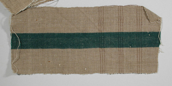 Hearst Museum object titled Textile fragment, accession number 5-11030, described as Textile sample (section of narrow band weaving). Brown-gray-beige ground with 2.4 cm central green stripe. Horizontal maroon striping in series of three lines separated by narrow beige stripes; loops on left selvage.