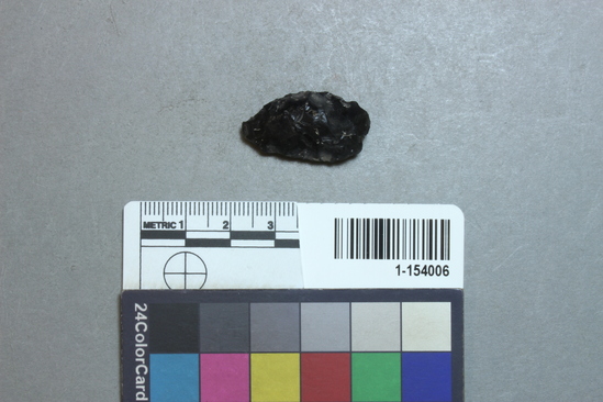 Hearst Museum object titled Point, accession number 1-154006, described as Proximal or distal fragment of thick biface of obsidian; type unknown.  Two generations of flaking represented on broken surface.  Length= 28.7mm; width= 14.5mm; thickness= 10.4mm.