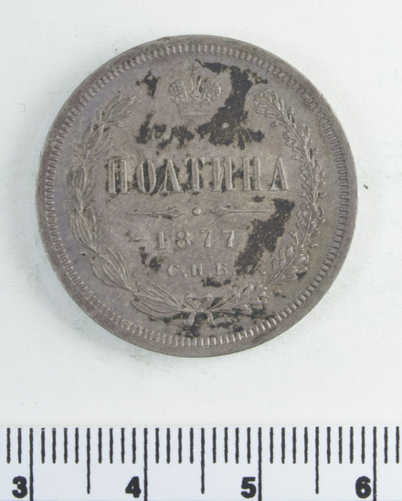 Hearst Museum object 4 of 4 titled Coin, accession number 7-2754, described as Coin; silver; obverse: imperial crest; чистаго серебра 2 золотника 10 1/2 долей; transl: pure silver 2 zolotniks 10 1/2 shares; reverse: полтина 1877 С.П.Б.; transl: poltina 1877 S.P.B.; weight 10.23 grams.