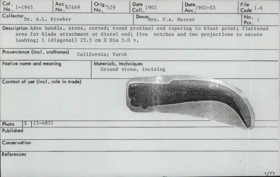 Documentation associated with Hearst Museum object titled Adze handle, accession number 1-1945, described as Adze handle, stone, curved; round proximal end tapering to blunt point.  Flattened area for blade attachment at distal end.  Five notches and two projections to secure lashing.  Ground stone; incised.