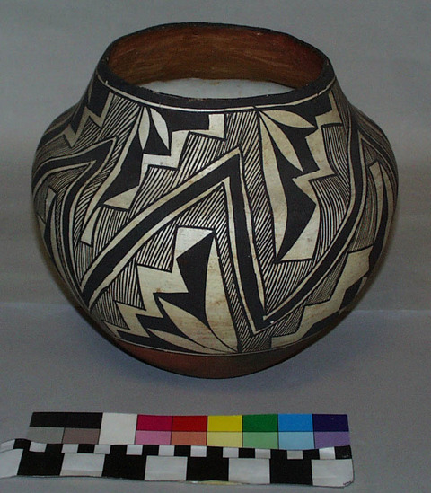 Hearst Museum object titled Bowl, accession number 2-18692, described as Pottery, geometric design with areas filled in with lines, black on white ground, black framing lines and rim, red base, paper sticker near base on which in printed "From the Pueblo of Acoma", fire smudged.