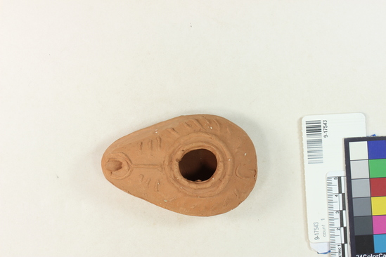 Hearst Museum object 1 of 2 titled Oil lamp, accession number 9-17543, described as clay lamp; tear-drop shape; press-mold relief design on top half, geometric patterns; 9 cm
