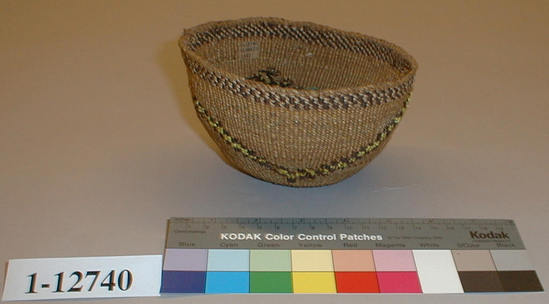 Hearst Museum object titled Food basket, accession number 1-12740, described as Food Basket; twined. Warp is twisted Tule (Schoenoplectus acutus), weft is twisted Tule and Cattail (Typha latifolia). Black pattern is Tule root. Yellow dye is Porcupine quills (Erethizon dorsatum) in lichen. Indigenous name: maksha.  Same as 12739 but smaller.  Figure a zigzag horizontal stripe of deep red with yellow porcupine quills.