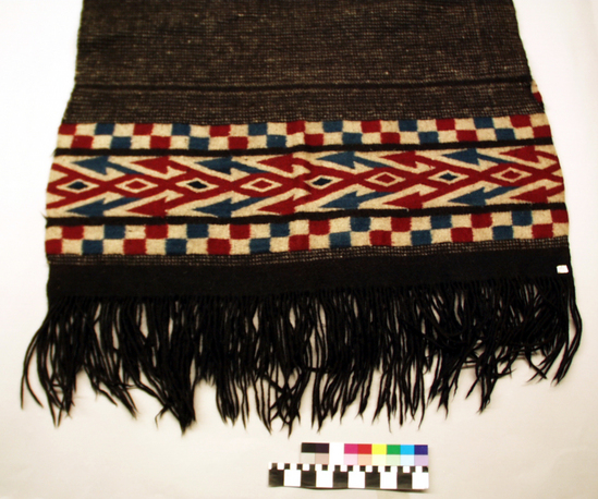 Hearst Museum object 3 of 4 titled Chamarro, accession number 3-121, described as Indian zarape or chamarro; 3-121 tapestry and twill weaves; natural black and white wool with red and blue dyed design in red, white, and blue; also black and white twill pattern; warp form fringes on ends; approximately 1 m 58 cm long plus 20 cm fringe at ends; approximately 92 cm wide