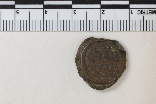 Hearst Museum object titled Coin: æ 10 nummia (decanummium), accession number 6-23153, described as Obverse: Two frontal busts separated by a cross. Reverse: an I surmounted by a cross potent flanked by Left: [symbol]; Right: [symbol resembling lowercase w] below in ex. [three symbols, the first resembling pi and the last resembling capital N] Denomination: decanummium Size: 1.8 cm Weight: 5.63 g Condition: poor Content: AE Provenience: Naga-ed-Der, Egypt. Hoard of 68 coins (6-23121-88) Mint Date: Alexandria Heraclitus 610-14 A.D. Reference: Warwick Wroth. Byzantine Coins.