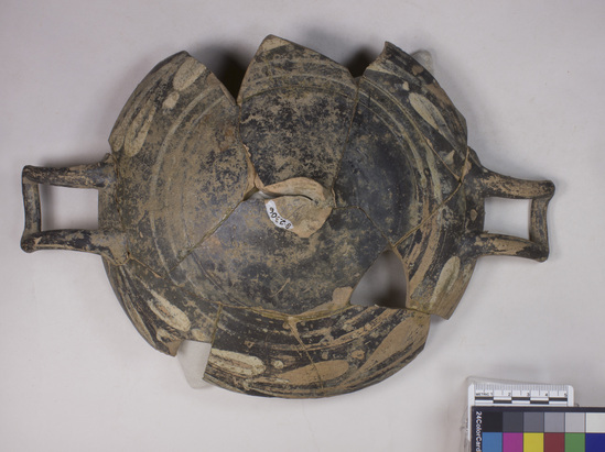 Hearst Museum object titled Incomplete kylix, accession number 8-2306, described as Overpainted kylix (drinking cup); interior: naked athlete and draped youth facing each other; exterior: white circles concentric to kylix including stem, still missing: quite worn.