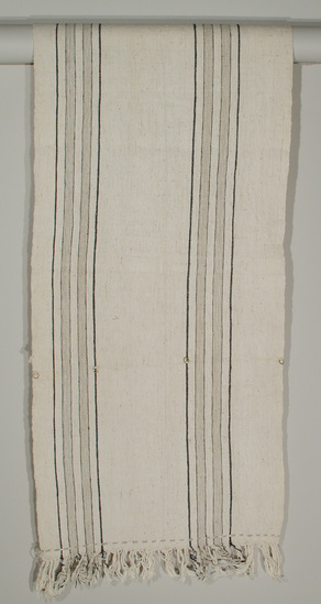 Hearst Museum object 2 of 4 titled Textile, accession number 5-16777, described as 1 panel tie dyed (indigo and white) fabric made into a curtain. design is made up of alternating bands of white and leaf patterns. Conservation: Brass rings at 37.5cm from finished end.