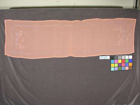 Hearst Museum object titled Shawl, accession number 18-448, described as Shawl; peach rayon crepe with drawnwork; belongs to 18-393. Worn by women. 43 x 164 cm.