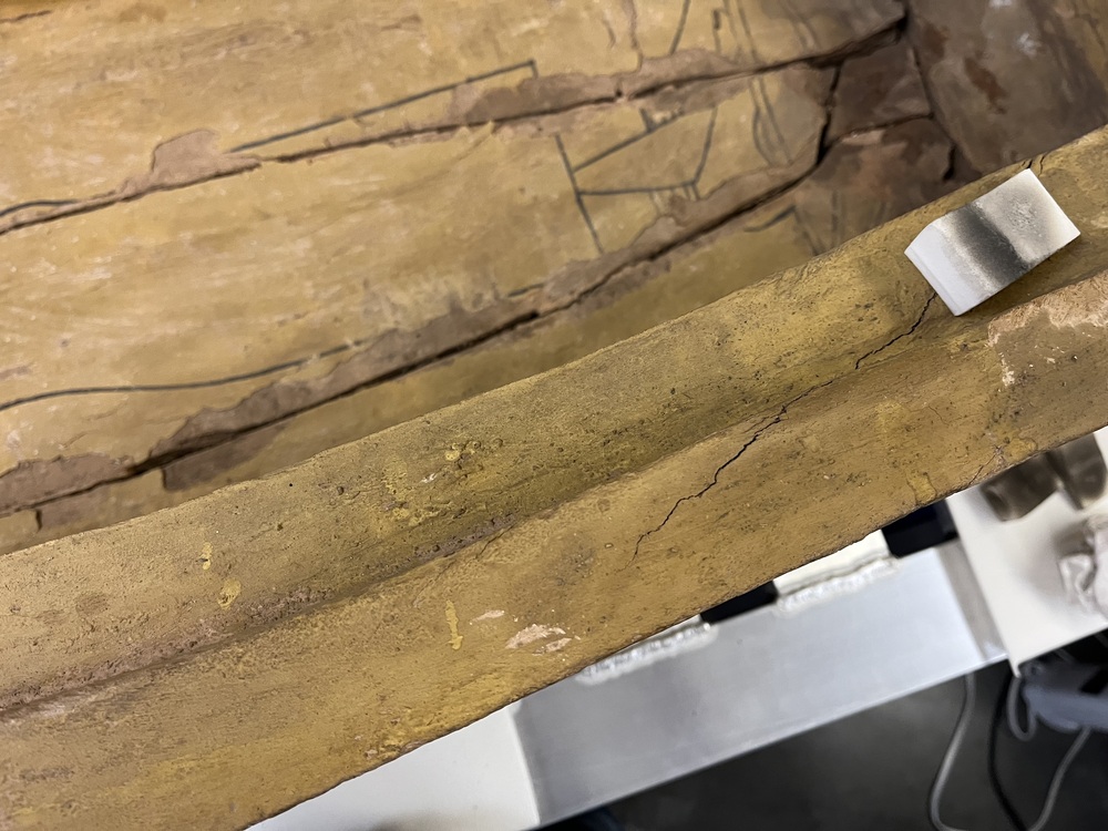 Hearst Museum object 24 of 167 titled Coffin, accession number 6-19912, described as Wooden anthropoid coffin. Inscription running down center of lid. Determined by Kea Johnston to probably be the outer coffin of Iwefaa (6-19928, 12-11039). According to Kea Johnston, "This coffin belonged to a man named Iwefaa, whose name is inserted in the middle of the spells written in the two columns on the front. This coffin is likely the outer coffin for PAHMA 6-19928 based on the similarity of the owner's name, unusual costume, and the paleography of the inscription. Both coffins were purchased on the antiquities market by George Reisner for Phoebe A Hearst. However, stylistically, they are very similar to a set of coffins known to have come from the site of Akhmim, which was excavated in the 1880s by Gaston Maspero, and which has heavily looted for the antiquities market during this decade." "The pectoral vignette between the text and the collar shows the deceased standing before squatting baboon and is the source of our logo. The hieroglyph for 'sky' is above their heads, and the side borders are formed by a pyramid and the symbol for the West.